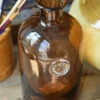Apothekers Fles Van Bruin Glas Met Sierlijk Embleem, IB Laursen 2 Apothekers Fles Van Bruin Glas Met Sierlijk Embleem, IB Laursen -Woondecoratie apothekers fles van bruin glas met sierlijk embleem ib laursen